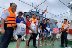 Các chiến sỹ hải quân công tác trên huyện đảo Trường Sa hỗ trợ lương thực, thực phẩm cho ngư dân Bình Thuận. (Ảnh: TTXVN phát)
