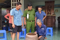 Ông Nguyễn Văn Chiến (ngồi) trình báo với cơ quan chức năng khi bắt được tê tê. (Ảnh: Thanh Liêm/TTXVN)
