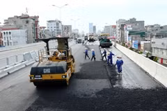Thi công trải lớp bê tông nhựa ở đường vành đai 3 trên cao. (Ảnh: Huy Hùng/TTXVN)
