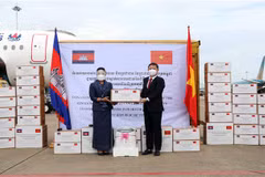 Bà Youk Sambath, Quốc vụ khanh Bộ Y tế Campuchia (trái), trao tượng trưng số hàng của Chính phủ Hoàng gia và nhân dân Campuchia hỗ trợ công tác phòng, chống dịch COVID-19 của Thành phố Hồ Chí Minh cho ông Dương Anh Đức, Phó Chủ tịch UBND Thành phố Hồ Chí 