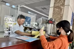 Người dân thực hiện giao dịch tại Cục Thuế. (Ảnh: Hứa Chung/TTXVN)
