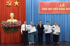 Lãnh đạo Tỉnh ủy An Giang trao tặng Huy hiệu 55 năm tuổi Đảng cho các đảng viên cao niên tuổi Đảng. (Ảnh: Thanh Sang/TTXVN)