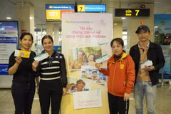 Người lao động cầm tấm vé bay và được được chuyên chở miễn phí trên chuyến bay của Vietnam Airlines. (Ảnh: PV/Vietnam+)