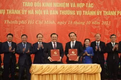 Ông Đinh Tiến Dũng, Bí thư Thành ủy Hà Nội và ông Nguyễn Văn Nên, Bí thư Thành ủy Thành phố Hồ Chí Minh ký kết biên bản hợp tác giữa hai thành phố. (Ảnh: Anh Tuấn/TTXVN)