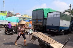 Một nữ lao động bốc xếp tại chợ Long Biên. (Ảnh: Nguyễn Văn Cảnh/TTXVN)