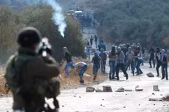 Binh sỹ Israel bắn đạn hơi cay vào người biểu tình Palestine ở khu Bờ Tây. (Ảnh: AFP/TTXVN)