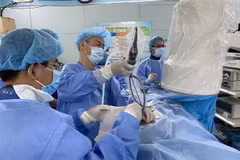 Bác sỹ Bệnh viện Bình Dân phẫu thuật nội soi qua da lấy sỏi thận cho bệnh nhi 3 tuổi. (Ảnh: TTXVN)