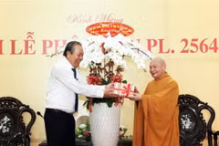 Ủy viên Bộ Chính trị, Phó Thủ tướng Thường trực Chính phủ Trương Hòa Bình (trái) tặng hoa chúc mừng Hòa thượng Thích Thiện Nhơn, Chủ tịch Hội đồng Trị sự, Giáo hội Phật giáo Việt Nam (phải) và các tăng ni, phật tử nhân Đại lễ Phật đản. (Ảnh: Xuân Khu/TTXV
