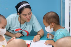 Chị Lê Thị Mai, Chủ nhiệm Câu lạc bộ Nét chữ xinh, phụ trách 'Lớp học vui vẻ' đang giảng bài cho học trò. (Ảnh: Đinh Hằng/TTXVN)