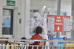 Nhân viên y tế bệnh viện Thanh Nhàn lấy mẫu xét nghiệm COVID-19 cho người đến khám có triệu chứng. (Ảnh: Minh Quyết/TTXVN)