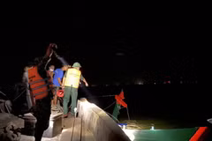 Lực lượng chức năng cùng người dân kéo tàu cá gặp nạn vào bờ. (Nguồn: plo.vn)