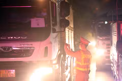Lực lượng CSGT kiểm tra giấy tờ các phương tiện giao thông đăng ký luồng xanh trước khi di chuyển vào Hà Nội. (Ảnh: Phạm Kiên/TTXVN)