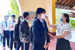 Thí sinh được đo thân nhiệt trước khi vào điểm thi. (Ảnh: Thu Hiền/TTXVN)