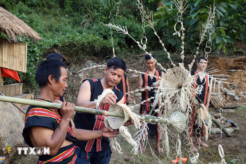 Những thanh niên trai tráng thôn Tak Xoai, xã Trà Leng trang trí cây nêu chuẩn bị cho Lễ cúng máng nước. (Ảnh: Đỗ Trưởng/TTXVN)