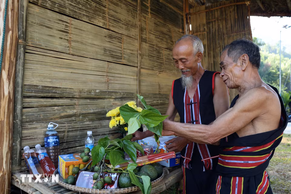 Hai già làng chuẩn bị lễ vật trước khi bước vào Lễ cúng máng nước của đồng bào M’Nông. (Ảnh: Đỗ Trưởng/TTXVN)
