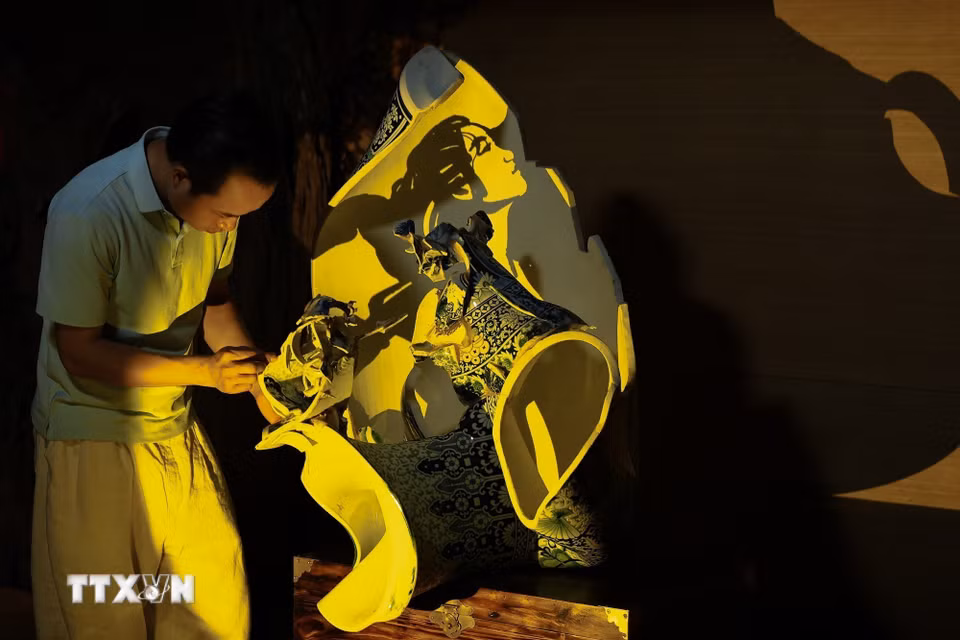 Nghệ nhân Bùi Văn Tự hoàn thiện tác phẩm “Vươn lên từ khát vọng” từ những mảnh gốm vỡ Bát Tràng, nhằm gửi gắm lời tri ân tới những người phụ nữ gắn bó với nghề gốm. (Ảnh: Phạm Tuấn Anh/TTXVN)