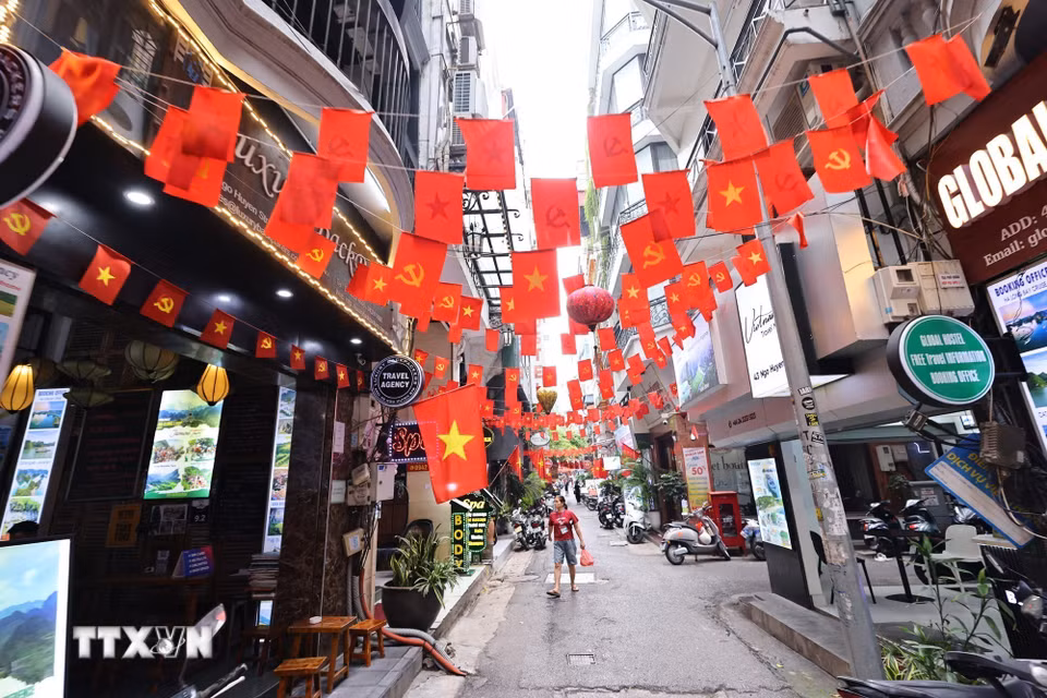 Cờ Tổ quốc và cờ Đảng trang hoàng rực rỡ ở Ngõ Huyện, phường Hoàn Kiếm. (Ảnh: Minh Đức/TTXVN)