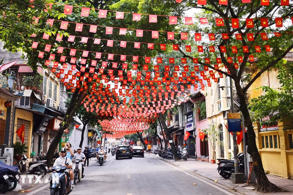 Cờ Tổ quốc và cờ Đảng trang hoàng rực rỡ trên phố Hàng Than. (Ảnh: Minh Đức/TTXVN)