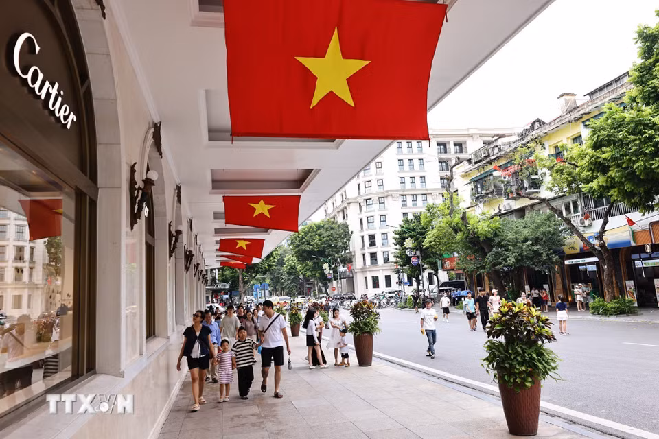 Cờ Tổ quốc cỡ lớn được bố trí tại khu vực trung tâm thương mại Tràng Tiền Plaza. (Ảnh: Minh Đức/TTXVN)