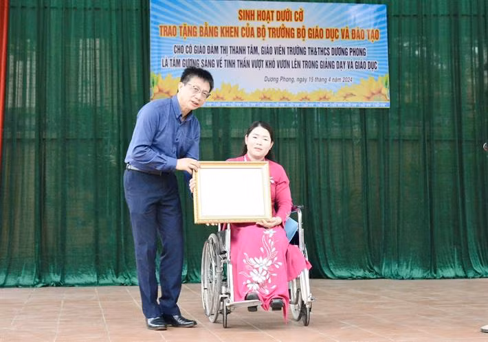 Chủ tịch Công đoàn Giáo dục Việt Nam Nguyễn Ngọc Ân trao Bằng khen của Bộ trưởng Bộ GDĐT cho cô giáo Đàm Thị Thanh Tâm. (Ảnh: Bộ GD-ĐT)