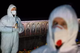 Các nhân viên nhà máy điện hạt nhân Chernobyl thắp nến tại đài tưởng niệm lính cứu hỏa và công nhân thiệt mạng sau thảm họa Chornobyl, trong lễ tưởng niệm 40 năm sau thảm họa, giữa bối cảnh xung đột Nga - Ukraine, tại thành phố Slavutych (TP đặc biệt được xây dựng để cho nhân viên nhà máy điện hạt nhân Chernobyl và gia đình họ sau thảm họa hạt nhân năm 1986) ngày 26-4-2026 - (Ảnh: REUTERS)