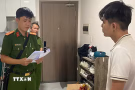 Cơ quan Cảnh sát điều tra đọc quyết định tạm giữ hình sự đối với Mai Minh Tấn. (Ảnh: TTXVN phát)