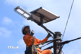 Nhân viên Điện lực Bắc Sơn thuộc Công ty Điện lực Lạng Sơn kiểm tra đèn LED của công trình “Thắp sáng đường thôn bằng đèn năng lượng mặt trời” cho thôn Tân Tiến, xã Bắc Sơn sau khi lắp đặt. (Ảnh: Anh Tuấn/TTXVN)