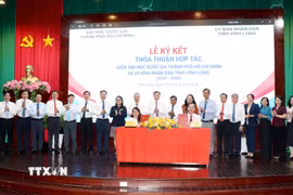 Lãnh đạo UBND tỉnh Vĩnh Long và Đại học Quốc gia Thành phố Hồ Chí Minh ký kết hợp tác. (Ảnh: Lê Thúy Hằng/TTXVN)