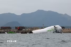 Lực lượng cứu trợ khẩn cấp làm nhiệm vụ tại hiện trường vụ máy bay chở hàng trượt khỏi đường băng và lao một phần xuống biển ở sân bay quốc tế Hong Kong, Trung Quốc ngày 20/10/2025. (Ảnh: REUTERS/TTXVN)