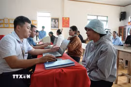 Nhiều người dân đến làm thủ tục hành chính tại nhà văn hóa thôn Chơ Ré (nay là thôn Tân Hạ, xã Tà Năng). (Ảnh: Nguyễn Dũng/TTXVN)