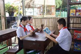 Học sinh hào hứng tìm hiểu về sách tiếng Việt tại Lễ Tôn vinh tiếng Việt tại Lào ở Trường Song ngữ Lào - Việt Nam Nguyễn Du ở thủ đô Vientiane. (Ảnh: Xuân Tú/TTXVN)