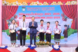 Đại sứ Nguyễn Minh Tâm trao tặng giấy khen cho học sinh đạt thành tích tốt trong kỳ thi học sinh giỏi cấp huyện, cấp thành phố năm học 2025 - 2026. (Ảnh: Xuân Tú/TTXVN)