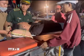 Lực lượng biên phòng đưa ngư dân Võ Kế Luân (27 tuổi) vào bờ để cấp cứu. (Ảnh: TTXVN phát)
