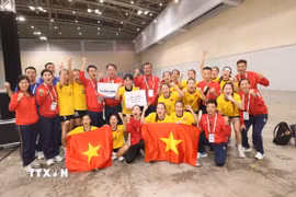 Các cầu thủ và ban huấn luyện tuyển bóng ném nữ Việt Nam ăn mừng với chiếc huy chương Vàng. (Ảnh: TTXVN phát)