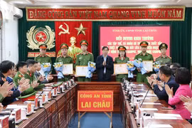 Chủ tịch Ủy ban Nhân dân tỉnh Lai Châu Lê Văn Lương tặng Bằng khen cho 14 cá nhân có thành tích xuất sắc trong thực hiện Chuyên án 0525L. (Ảnh: Nguyễn Oanh/TTXVN)