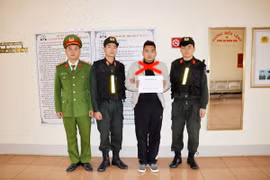 Đối tượng Lê Chí Hưng (mặc áo khoác trắng) tại Cơ quan Cảnh sát điều tra. (Nguồn: TTXVN)