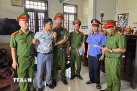 Thi hành lệnh bắt và khám xét nơi ở đối với bị can Mai Hoàng để phục vụ điều tra. (Ảnh: TTXVN phát)