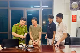Khám xét đối tượng Chảo Duần Chình tại cơ quan Công an. (Ảnh: TTXVN phát)
