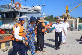 Đưa ngư dân gặp nạn vào đảo Song Tử Tây để điều trị gãy ngón tay do tai nạn lao động. (Ảnh: TTXVN phát)