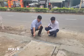 Đại diện đơn vị thi công và tư vấn giám sát kiểm tra vị trí hố thu nước trên tuyến đường Phú Riềng Đỏ, phường Bình Phước, thành phố Đồng Nai. (Ảnh: Đậu Tất Thành/TTXVN)