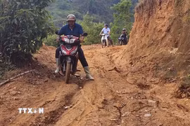 Người dân xã Bản Máy vất vả di chuyển trên những tuyến đường lầy lội, xuống cấp. (Ảnh: TTXVN phát)