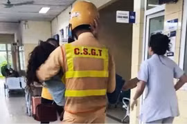 Hình ảnh chiến sỹ CSGT bế người phụ nữ tại hành lang bệnh viện lan truyền mạnh mẽ, nhận được nhiều lời khen ngợi từ cộng đồng. (Ảnh cắt từ clip)
