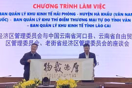 Lãnh đạo huyện Hà Khẩu (Vân Nam, Trung Quốc) tặng quà lưu niệm cho ông Lê Trung Kiên (phải), Trưởng ban Ban quản lý Khu kinh tế Hải Phòng. (Ảnh: Minh Thu/TTXVN)