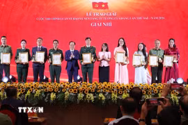 Ban Tổ chức trao giấy chứng nhận và biểu trưng cho các tác giả, nhóm tác giả đạt giải Nhì của Cuộc thi chính luận về bảo vệ nền tảng tư tưởng của Đảng lần thứ 6, năm 2026. (Ảnh: Văn Điệp/TTXVN)