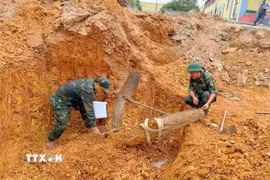 Quả bom nằm sâu dưới đất khoảng 2,5m được phát hiện khi công nhân đào móng xây dựng Trường Tiểu học Lưu Sơn, xã Đô Lương. (Ảnh: TTXVN phát)