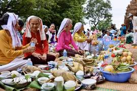 Người Chăm mang lễ vật lên tháp trong lễ hội Katê để dâng cúng thần linh và tổ tiên, cầu mong mưa thuận gió hòa, mùa màng bội thu và bình an cho gia đình. (Ảnh: Nhật Anh/TTXVN)