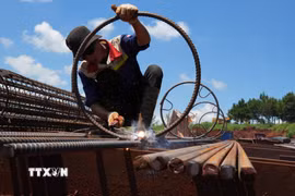 Một công nhân cho biết việc thi công cột khung cốt thép được tăng tốc cả khi trời nắng và trời mưa để đẩy nhanh tiến độ cho công trình. (Ảnh: Nguyễn Dũng/TTXVN)