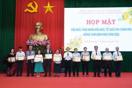 Lãnh đạo Ủy ban Nhân dân tỉnh Vĩnh Long trao Bằng khen cho các tập thể, hộ gia đình đã có thành tích tích cực ủng hộ vật chất xây dựng giao thông nông thôn và thực hiện công tác an sinh xã hội. (Ảnh: Phạm Minh Tuấn/TTXVN)