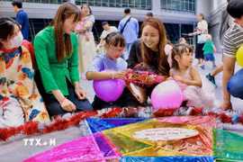 Các em nhỏ được hướng dẫn trang trí cho đèn ông sao tại chương trình vui Tết Trung thu tại Sakai, Osaka. (Ảnh: Nguyễn Tuyến/TTXVN)