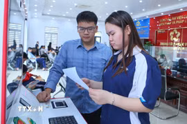 Cán bộ Trung tâm Phục vụ hành chính công xã Rạng Đông hướng dẫn người dân thực hiện thao tác tại Kiosk hành chính công. (Ảnh: Công Luật/TTXVN)